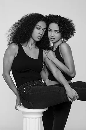 two women curly hair duo portrait bw