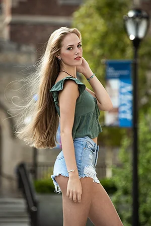 young woman green top denim shorts campus